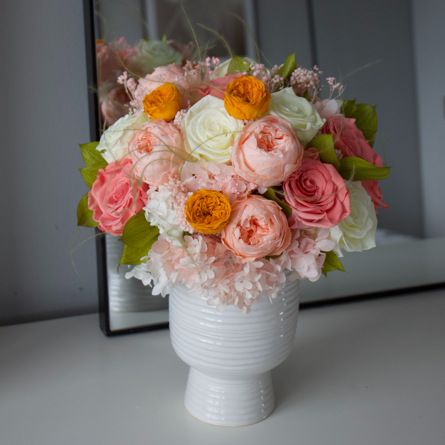 The Glimmer by Eos Blooms: a white vase with preserved pink, white & orange flowers.