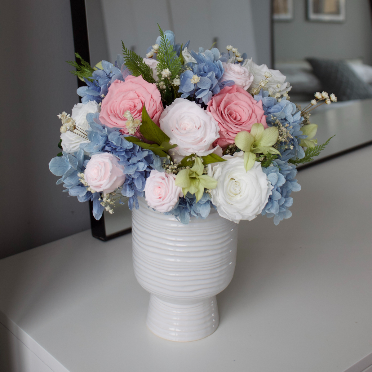 The Freyja preserved flower bouquet by Eos Blooms in a white vase on a white table.