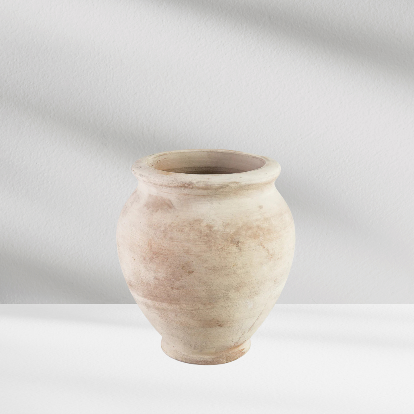 The Petra Vase by Eos Blooms: a simple, artisanal white clay vase with soft shadows.