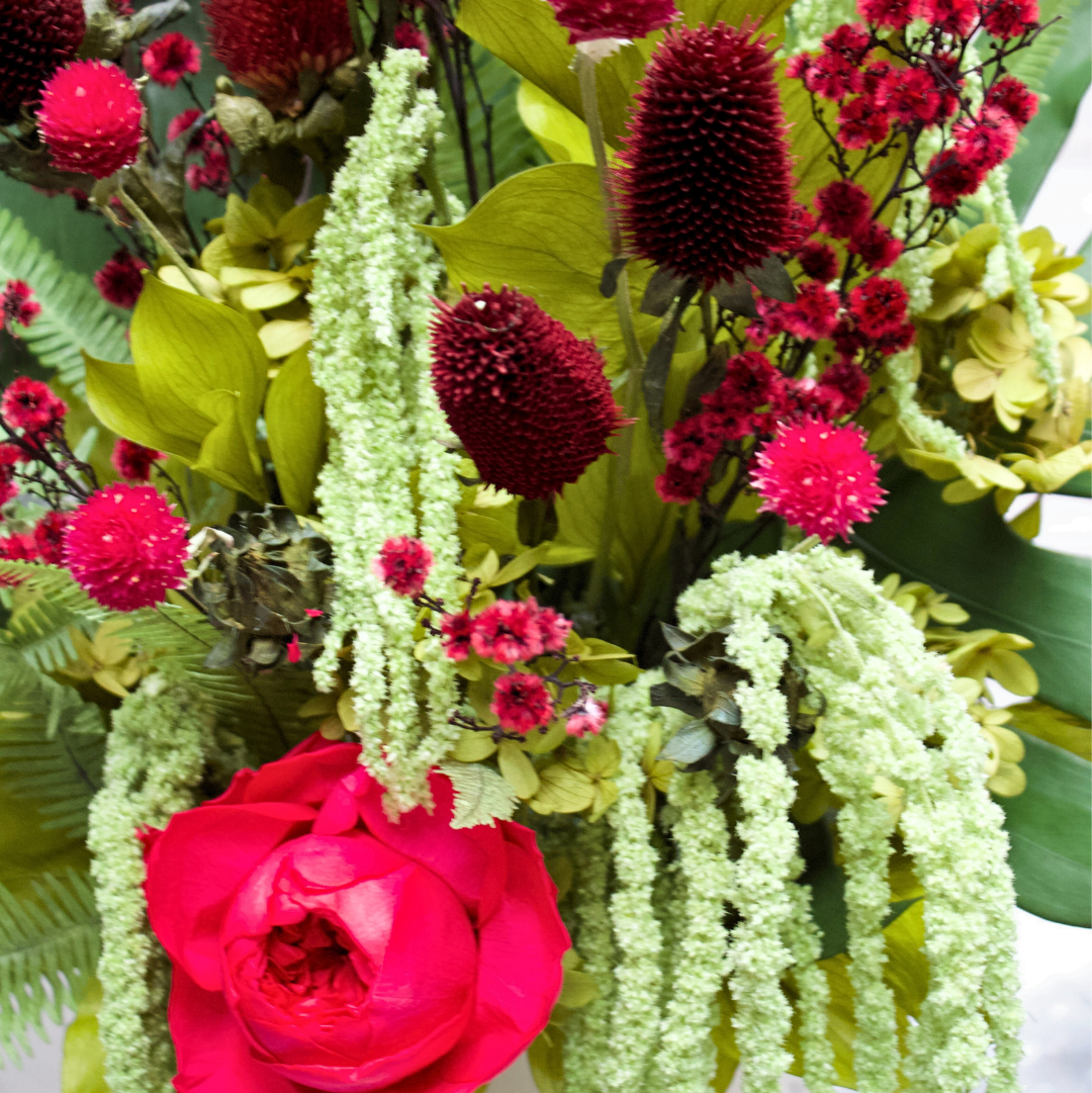 The Paradiso by Eos Blooms: a vibrant, long-lasting floral mix with reds, greens, and cascades.
