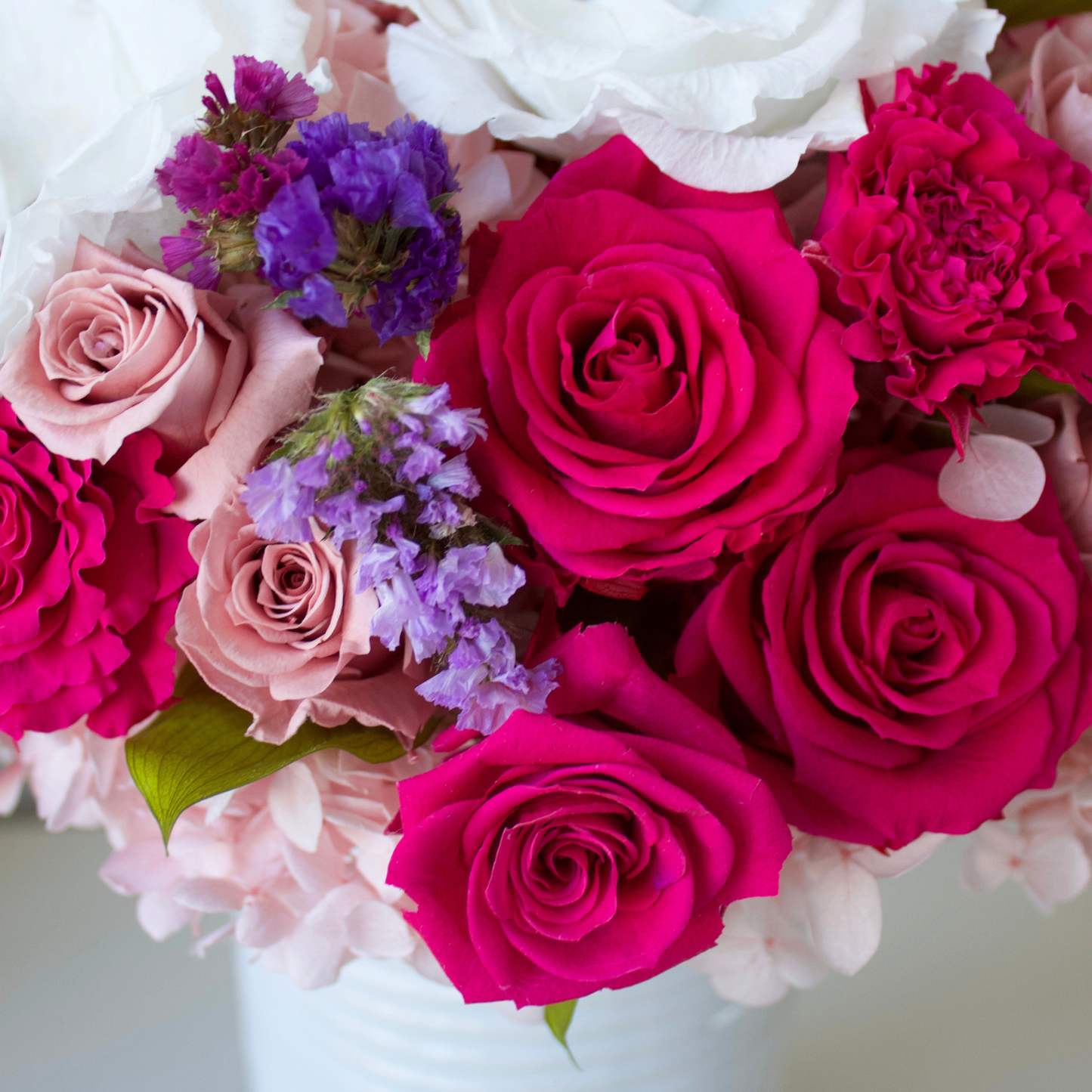 The Zenith by Eos Blooms: pink roses, purple, and white flowers in a chic white vase.