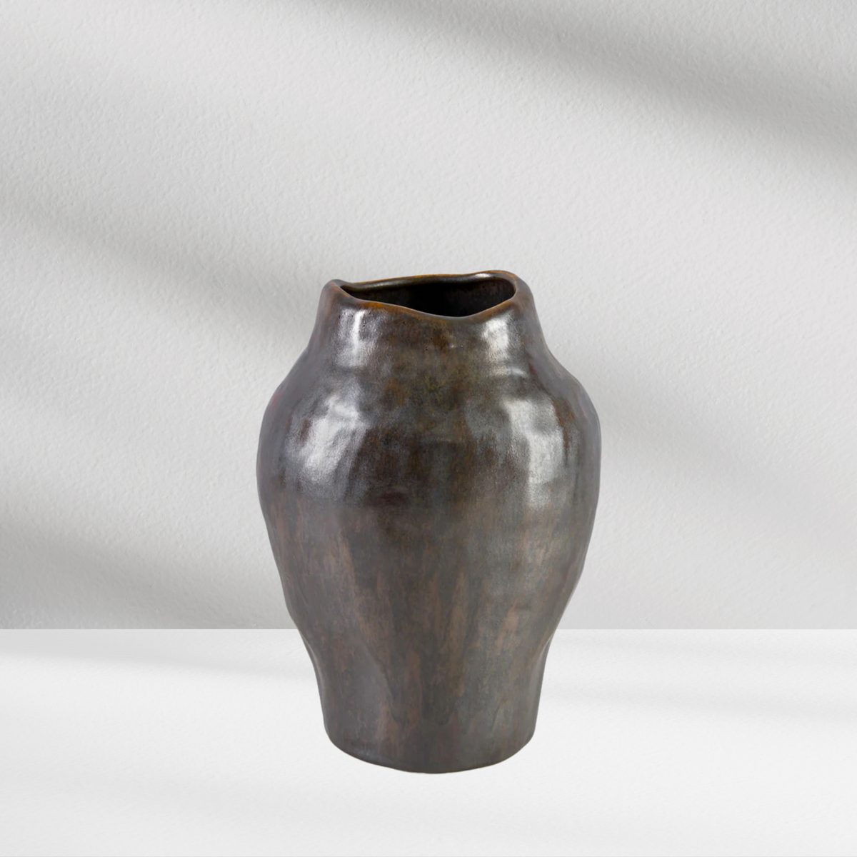The Angkor Vase by Eos Blooms: a dark, artisanal ceramic with an uneven shape.