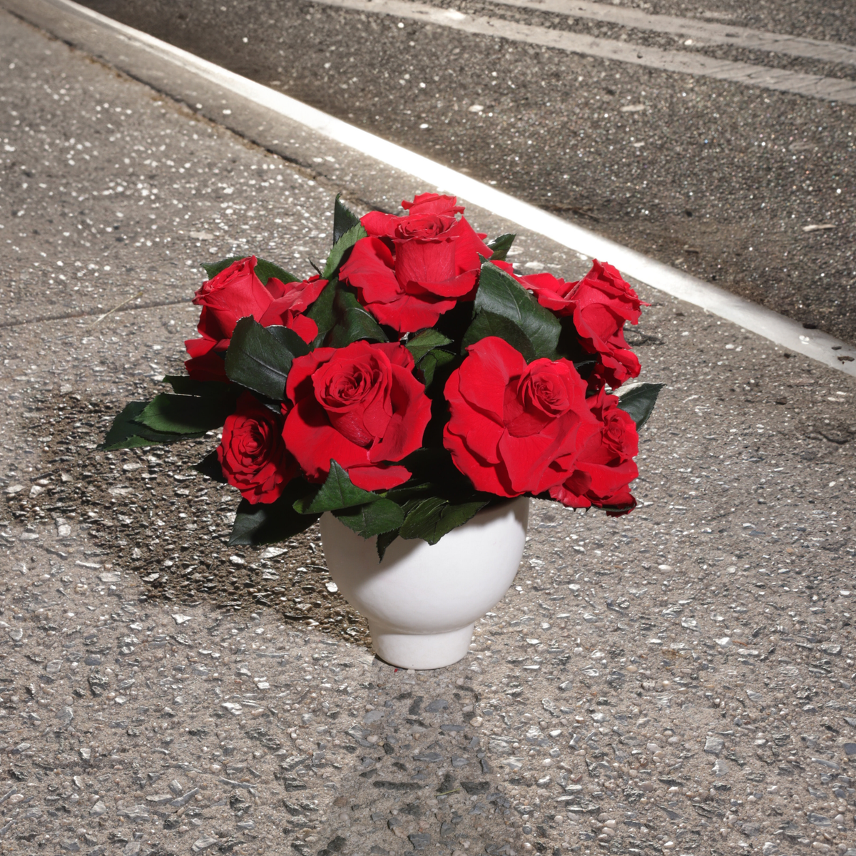 An Eden (Petite) by Eos Blooms sits on a city sidewalk near the street curb.