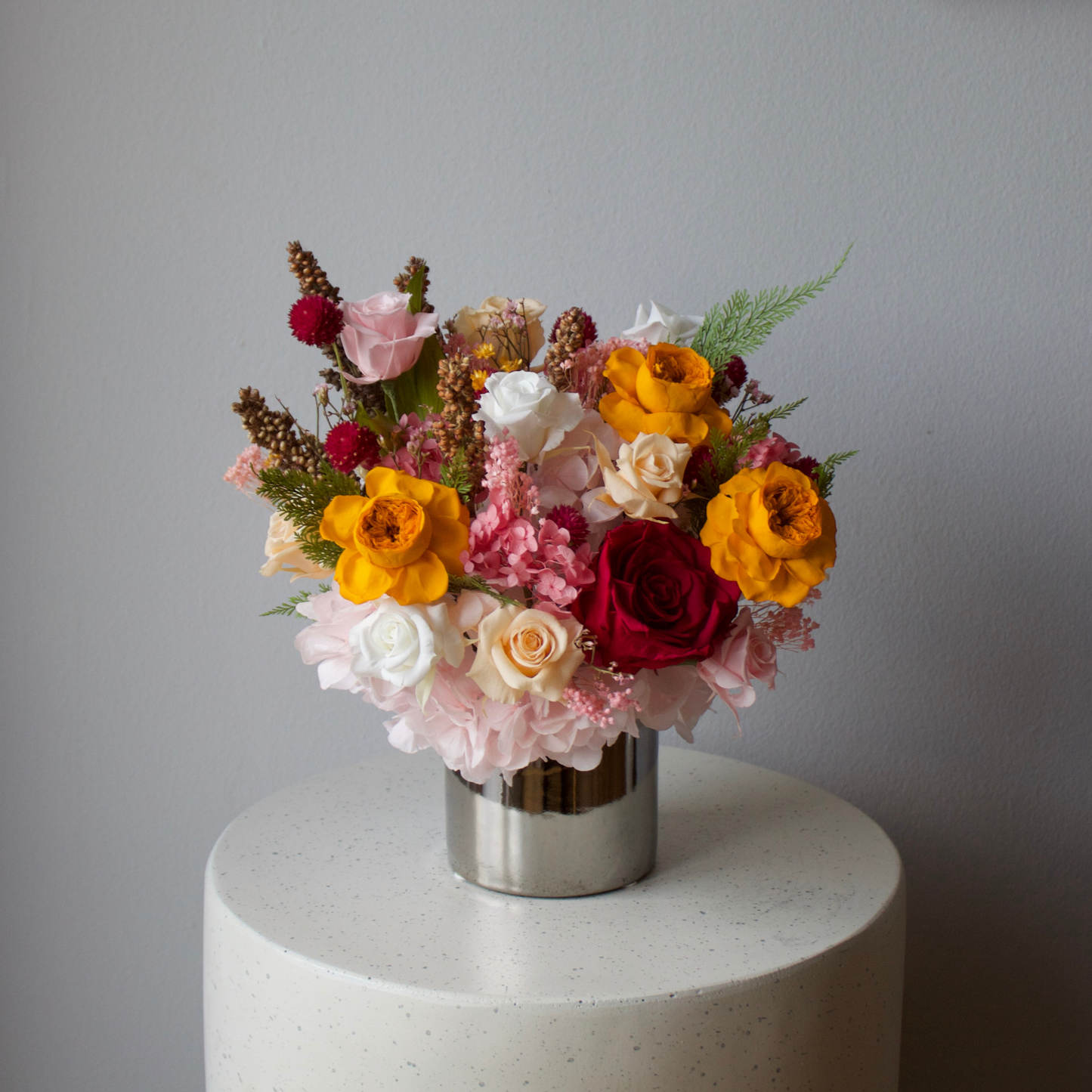 The Reverie (Petite) by Eos Blooms offers lasting preserved flowers in a chic silver vase.
