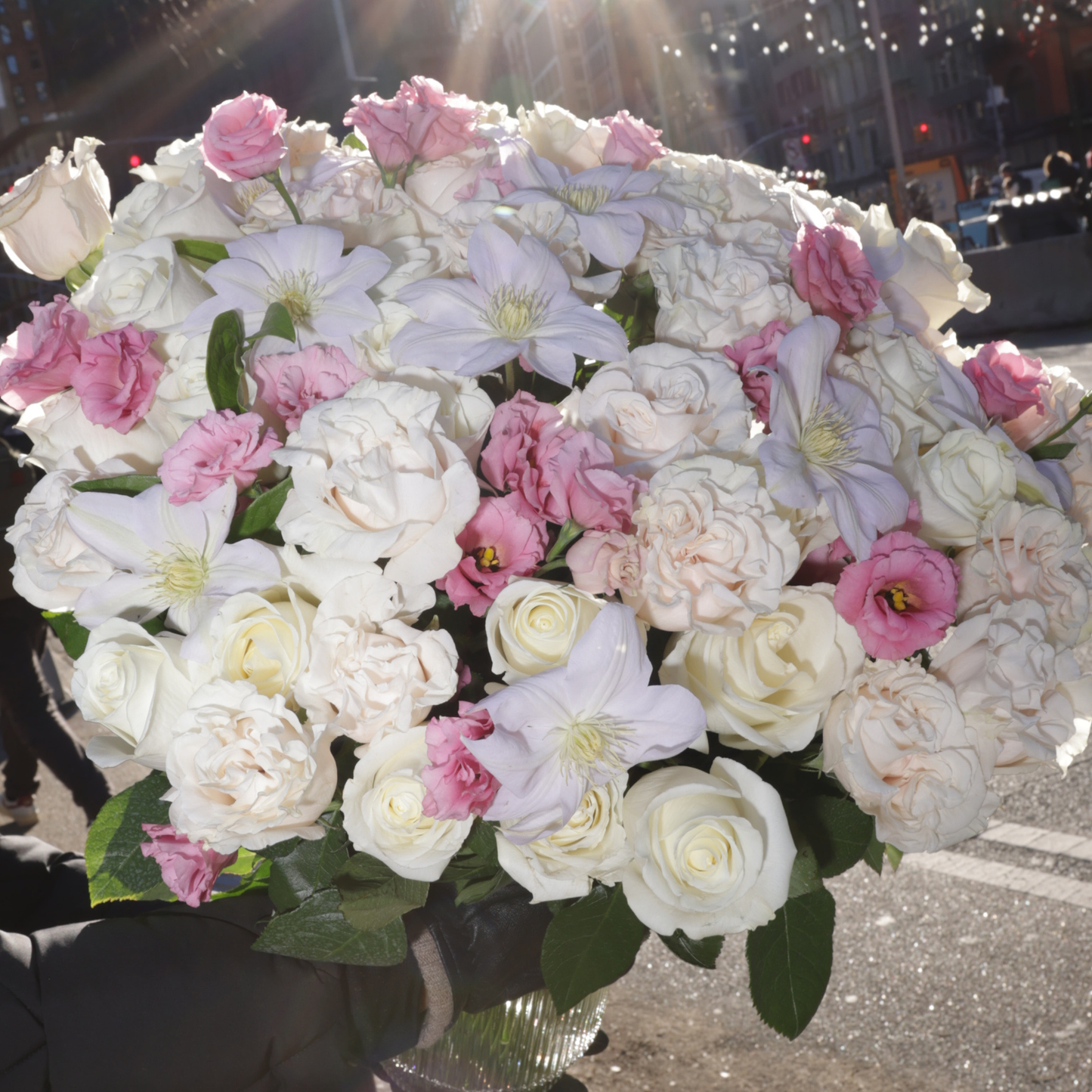 The XOXO by Eos Blooms: white and pink flower arrangement displayed outdoors in sunlight.