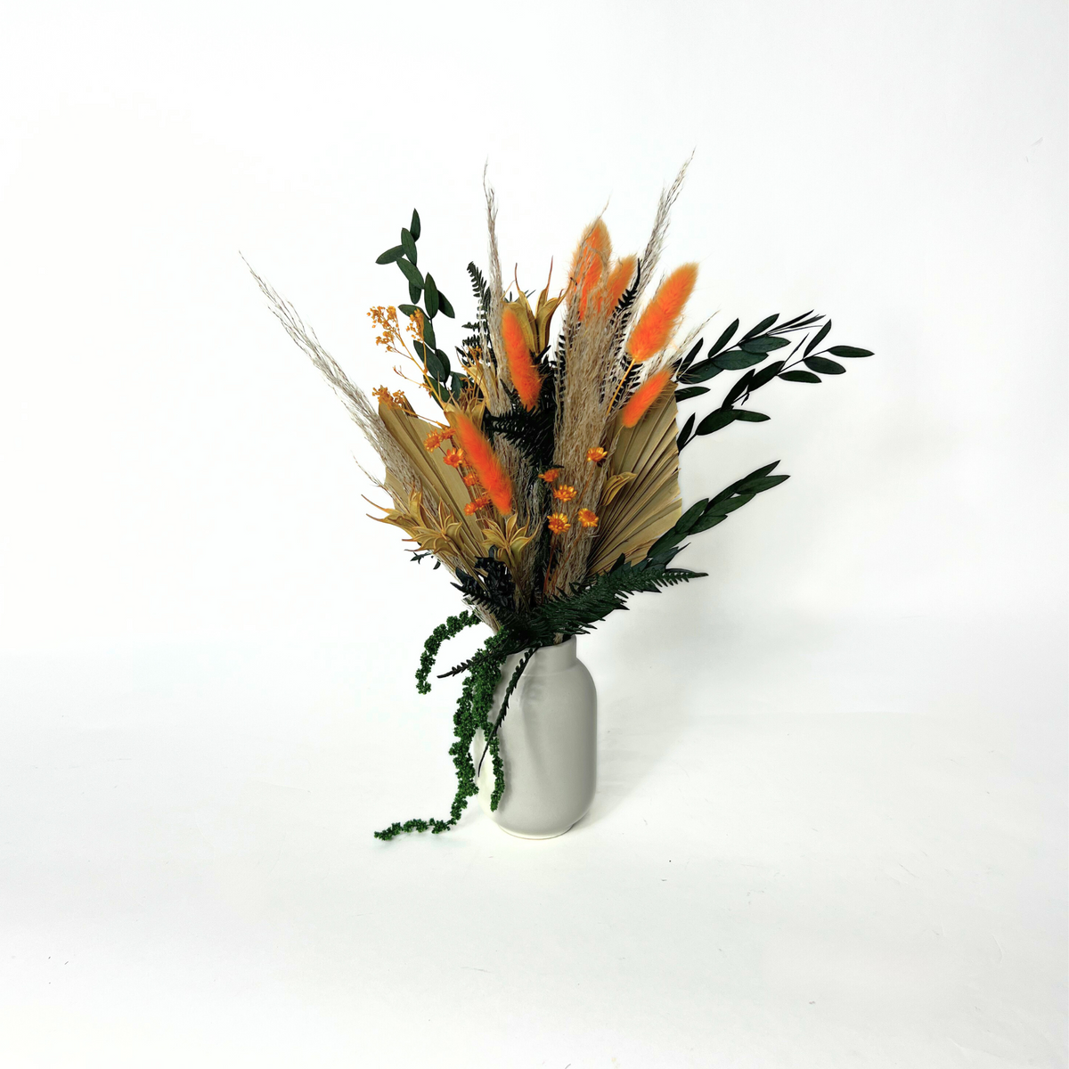 Harvest by Eos Blooms: a white vase with preserved flowers and dried orange, brown, green foliage.