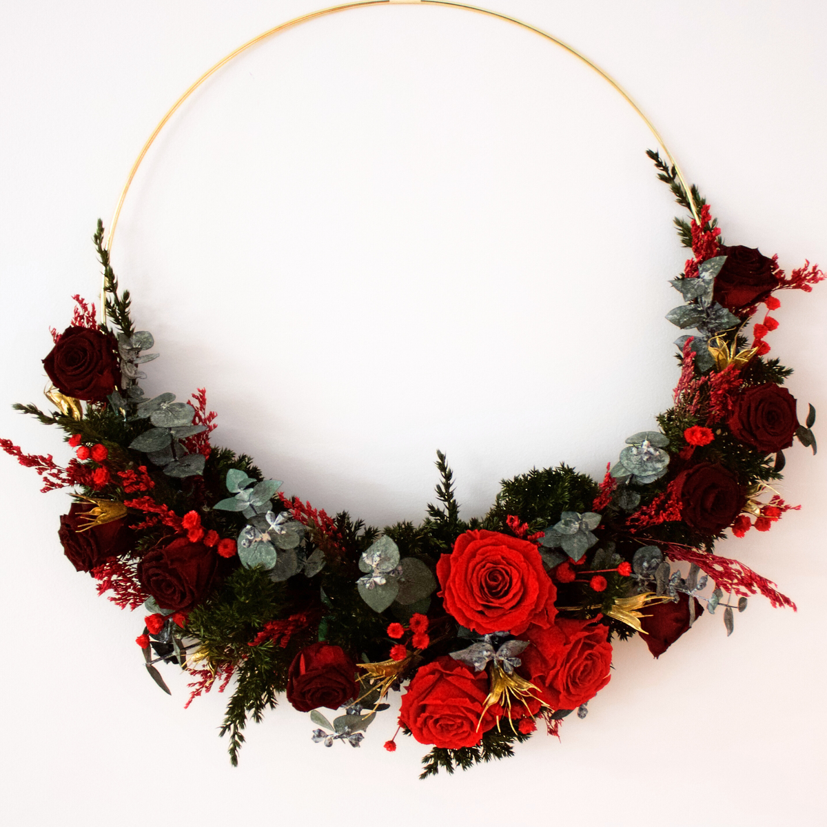 Eos Blooms Preserved Wreath with Forever Roses, holiday greenery, and red berries.