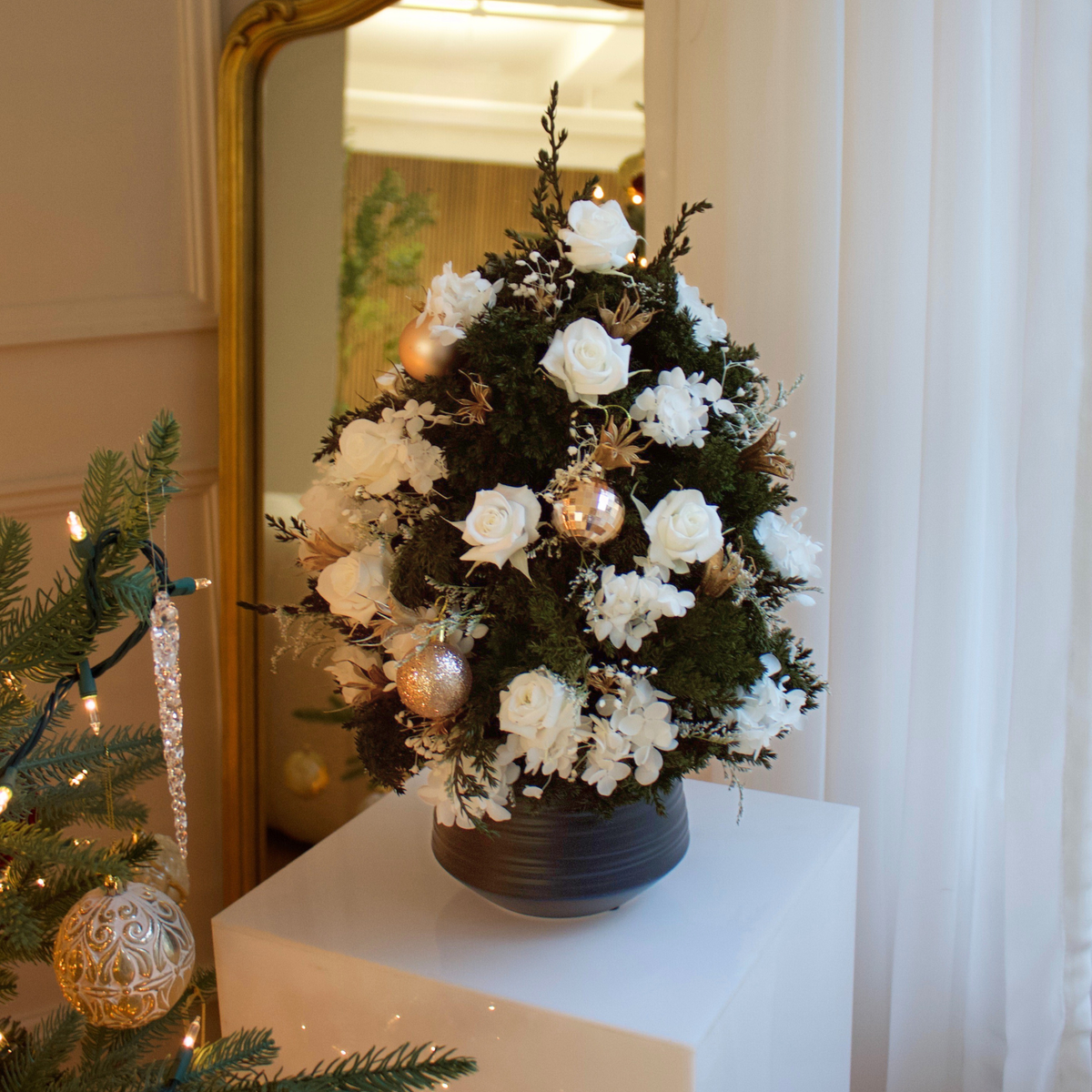 Eos Blooms Mini Preserved Tree with white flowers and ornaments in a black pot centerpiece.