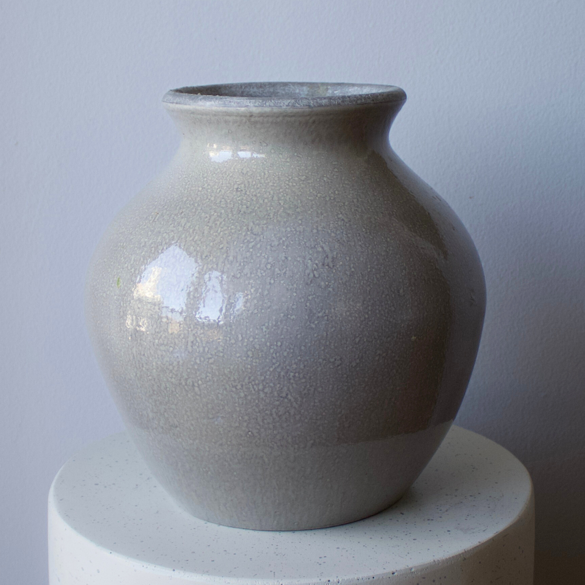 The Tulum Vase by Eos Blooms—a large, glossy ceramic vase on a white surface and gray wall.