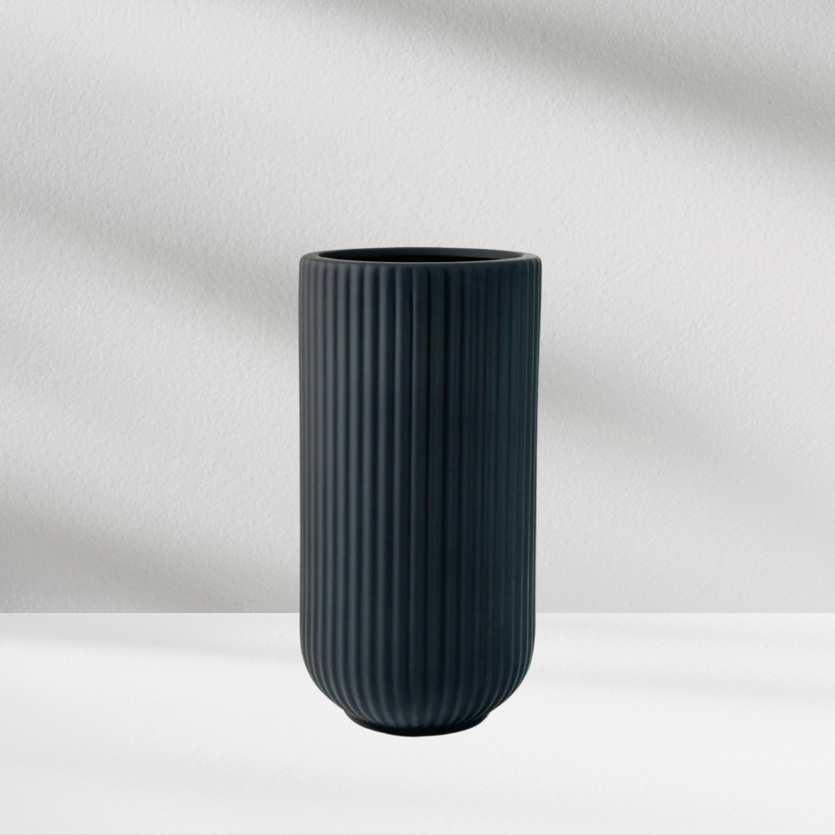 Oslo Vase by Eos Blooms: matte black ribbed design on a white surface with soft shadows.