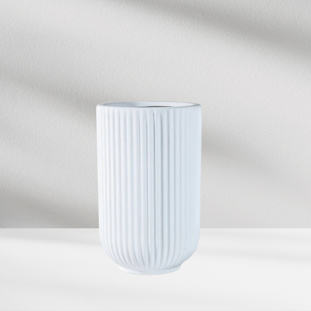 The Bergen Vase by Eos Blooms: a matte white ribbed ceramic vase with soft background shadows.