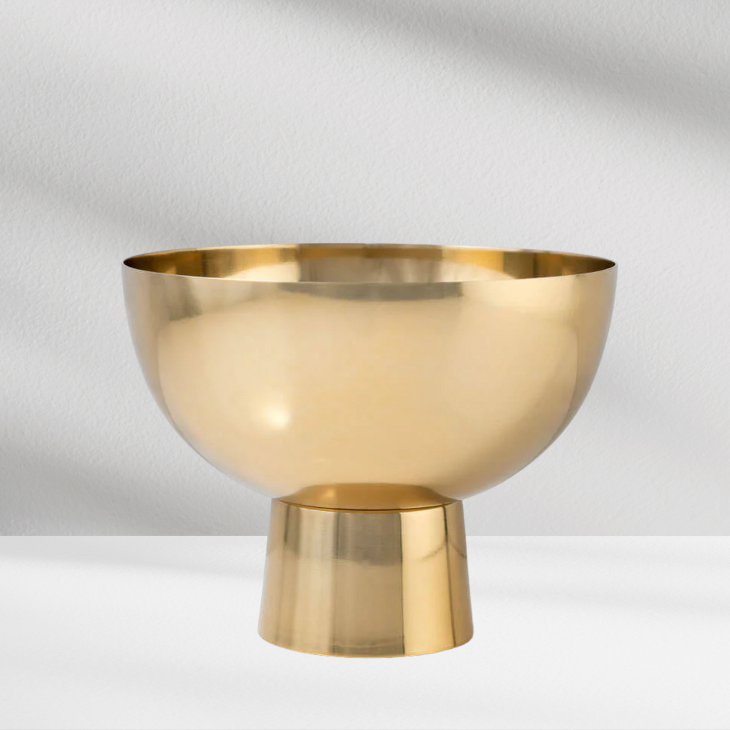 The Gold Pedestal by Eos Blooms is a shiny, wide-mouthed metal vessel with a cylindrical base.