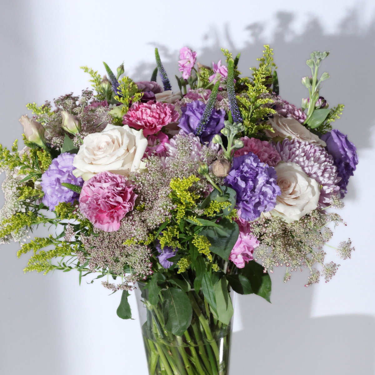 The Condesa | Hotel Guest by Eos Blooms: sand-toned roses and lavender lisianthus in glass vase.