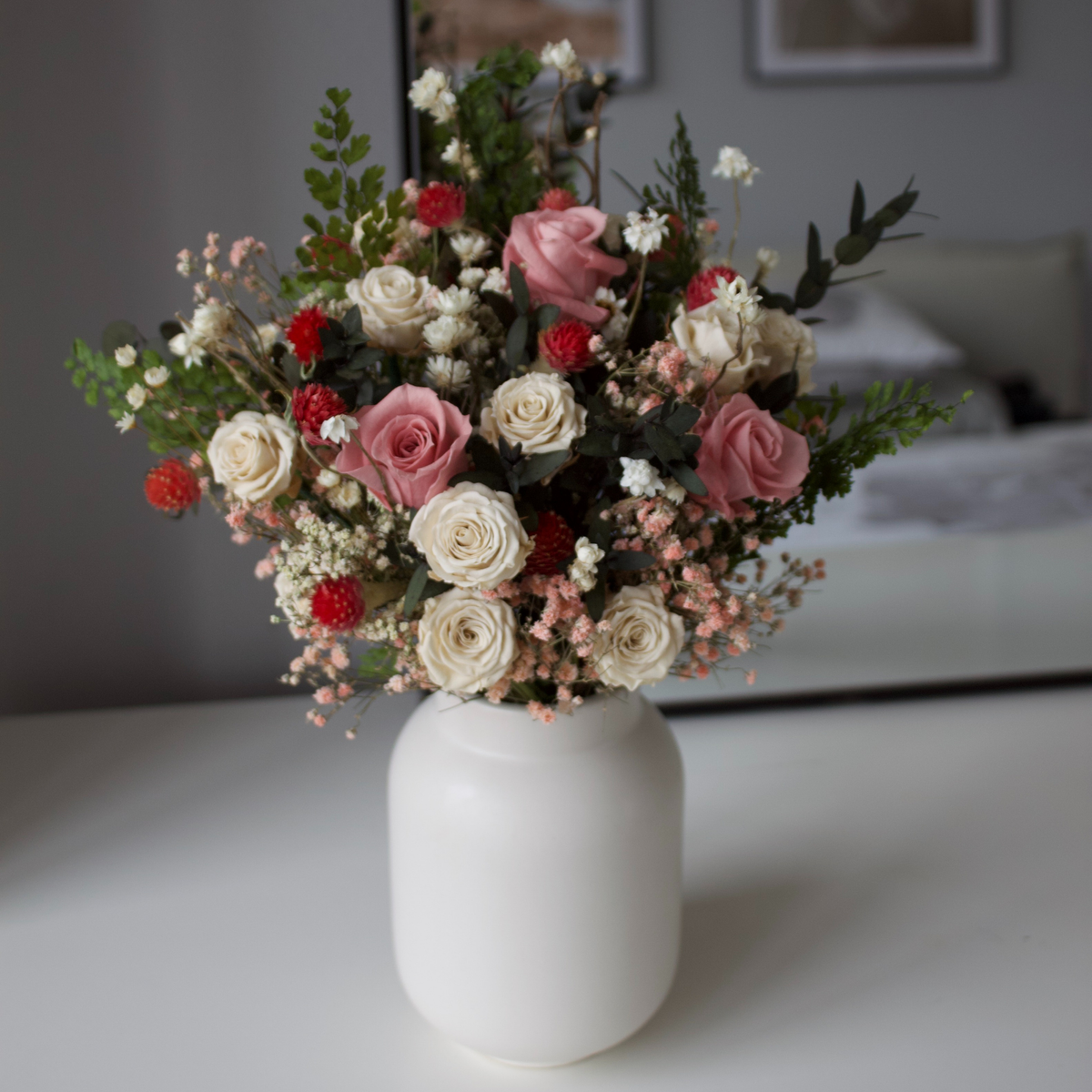 The Eire by Eos Blooms: a white vase with pink, white & red Forever Roses and green foliage.