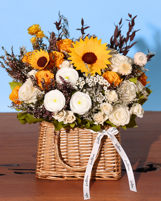 The Orchard | Autumn Basket by Eos Blooms holds sunflowers, Forever Roses, and lush greenery.