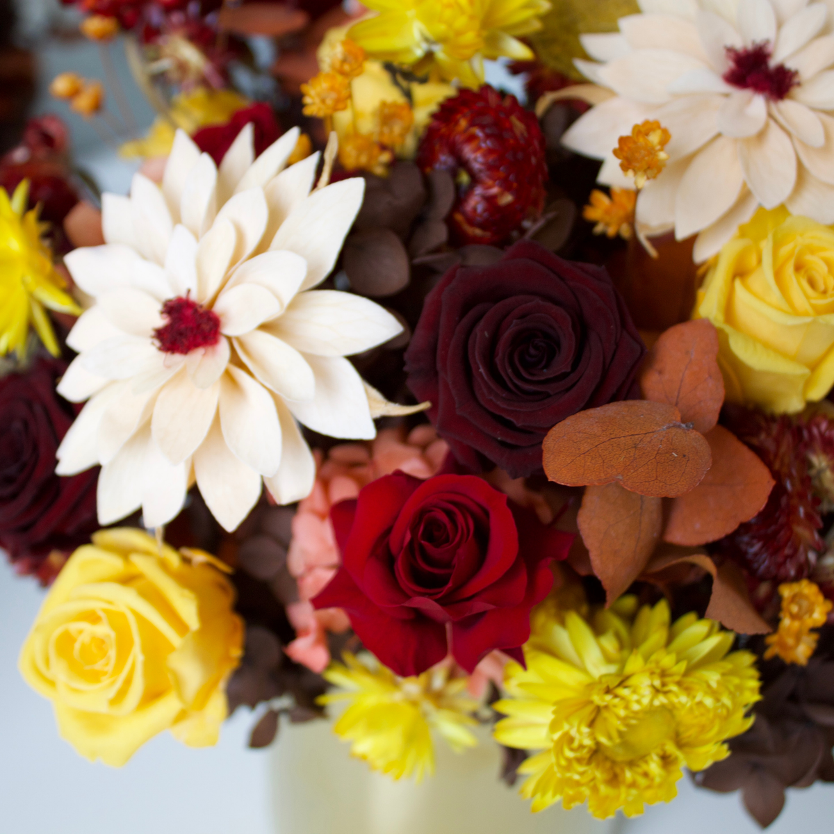 Golden Hour (Petite) by Eos Blooms: Forever Roses in autumn hues with brown leaves.