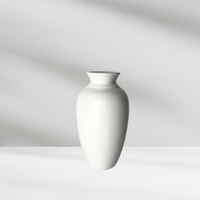 The Eos Blooms Ginger Vase sits on a white surface with soft shadows in the background.