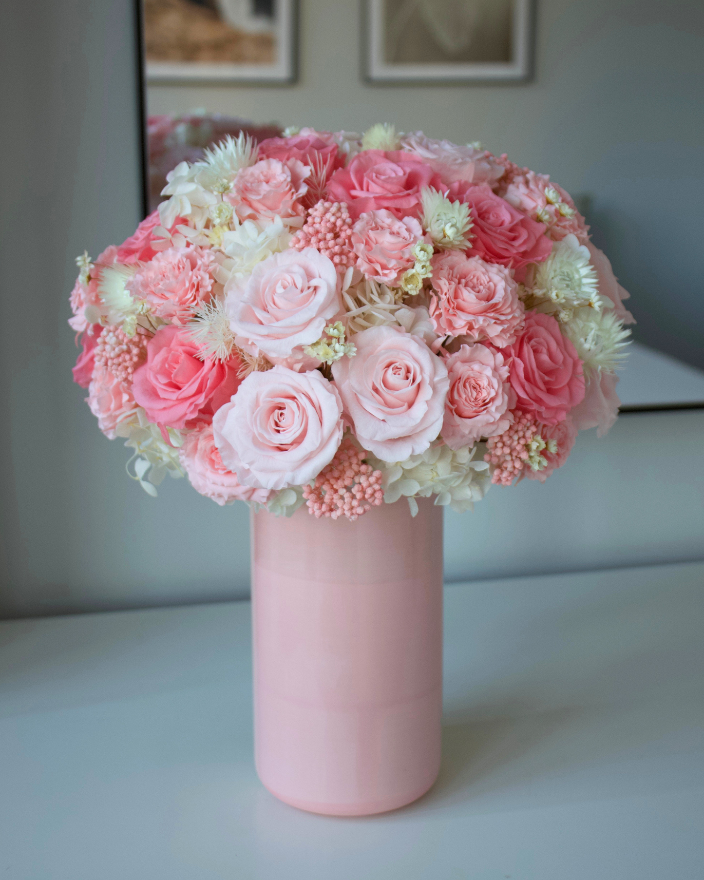 The Sugar Rush by Eos Blooms: preserved pink roses in a pink vase on a white table.