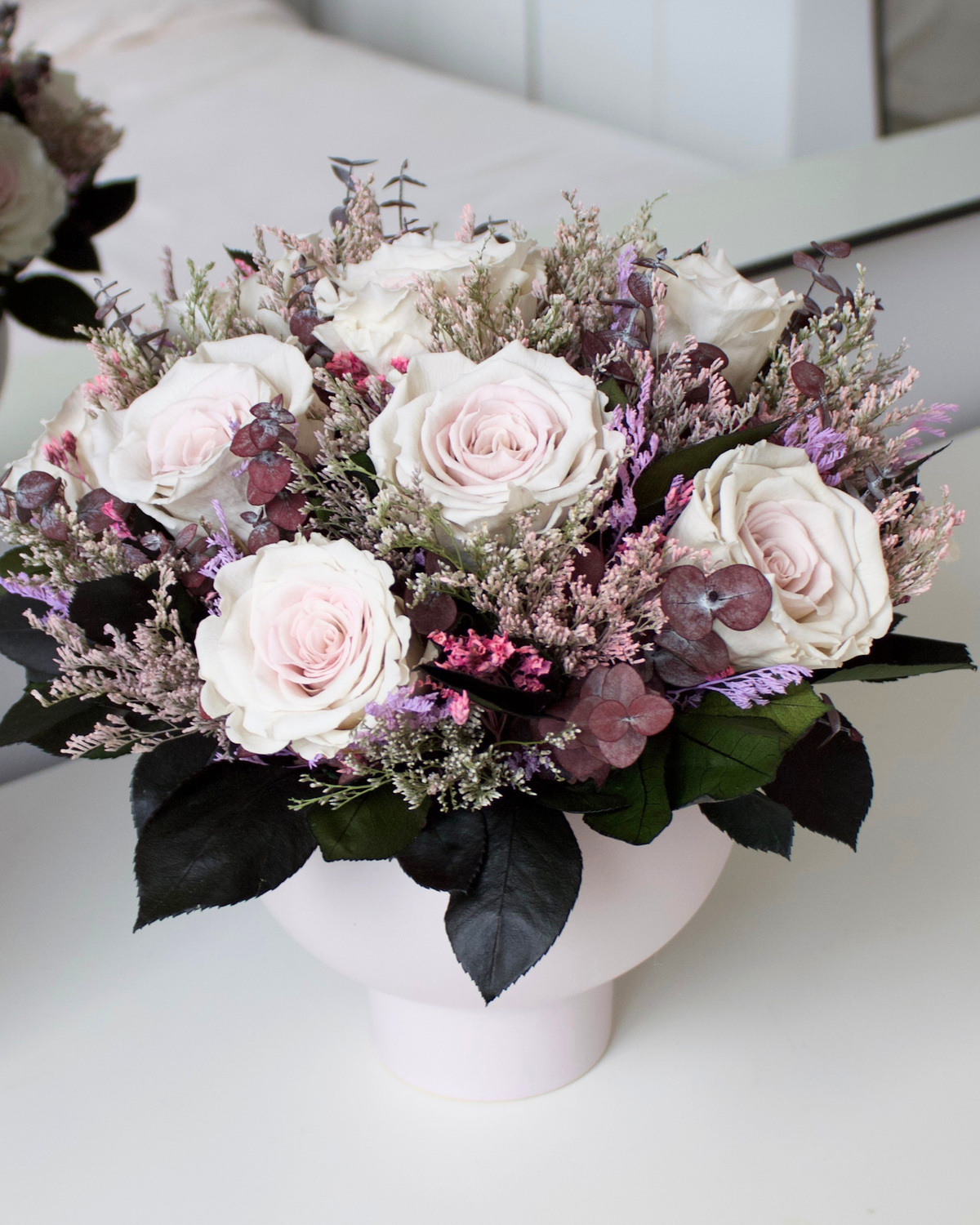 The Chantilly by Eos Blooms: white vase with pink and purple forever roses on a white surface.