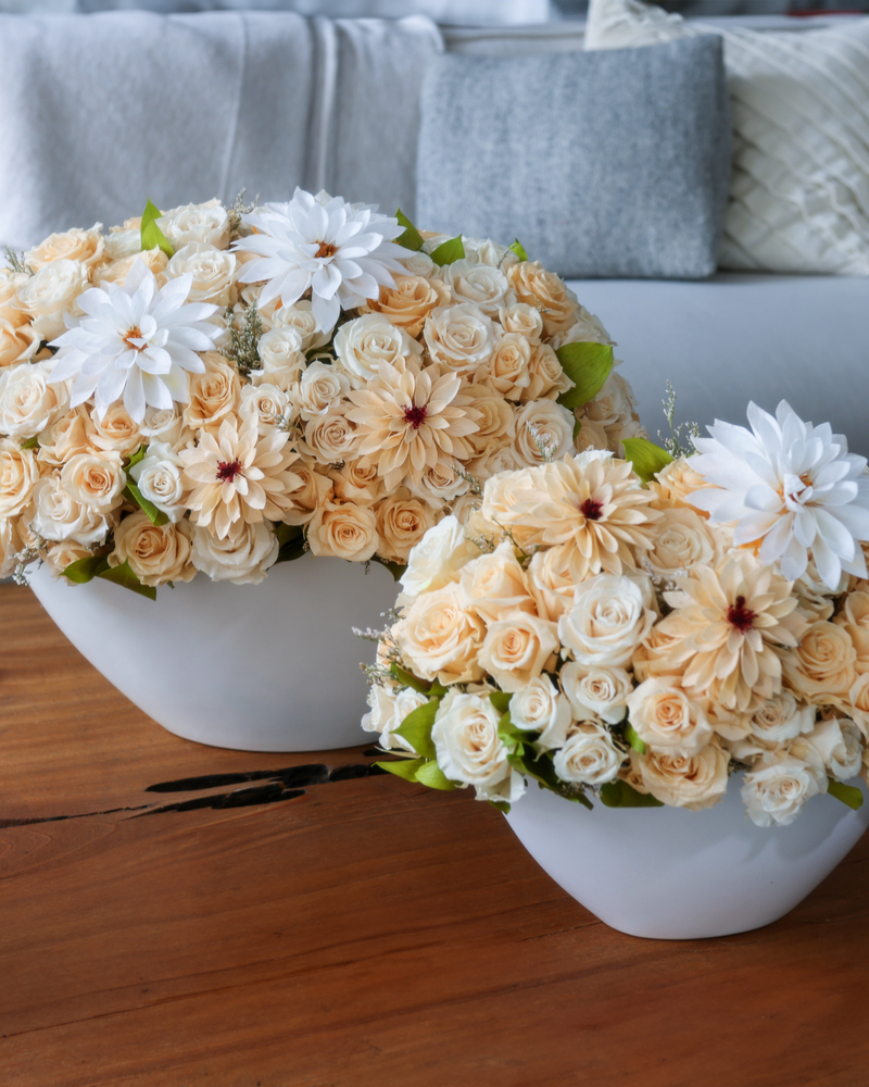 Flora Privé by Eos Blooms: cream rose and dahlia florals in white vases on a wood table.