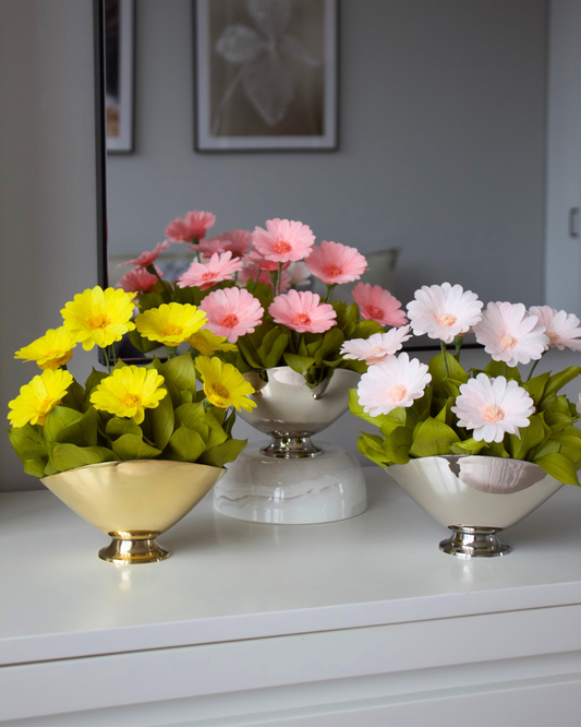 Three “The Margarita” preserved daisy bowls by Eos Blooms on a white dresser before a mirror.