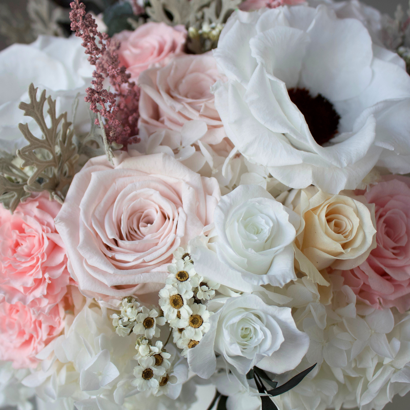 Close-up of The Gossamer by Eos Blooms with white, pink, and peach preserved roses and florals.