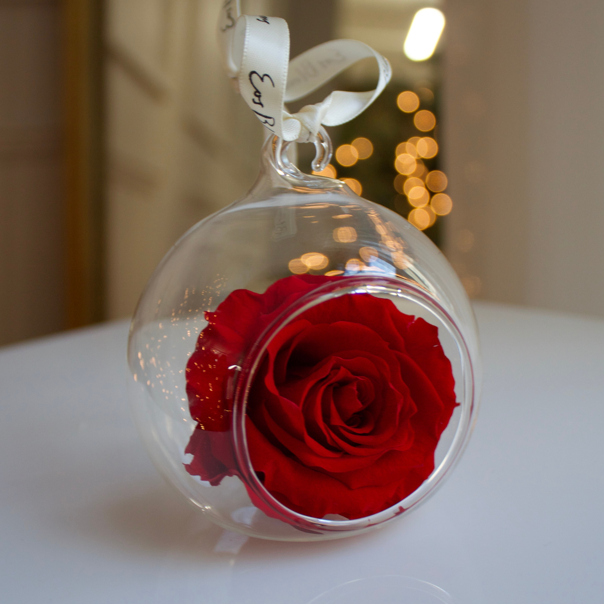 Eos Blooms Glass Ornaments 4-Pack with preserved rose and ribbon, on a white surface.