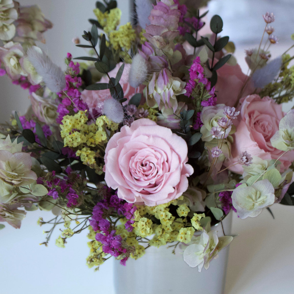 The Avonlea (Petite) by Eos Blooms: pink roses, yellow & purple flowers in a white vase.
