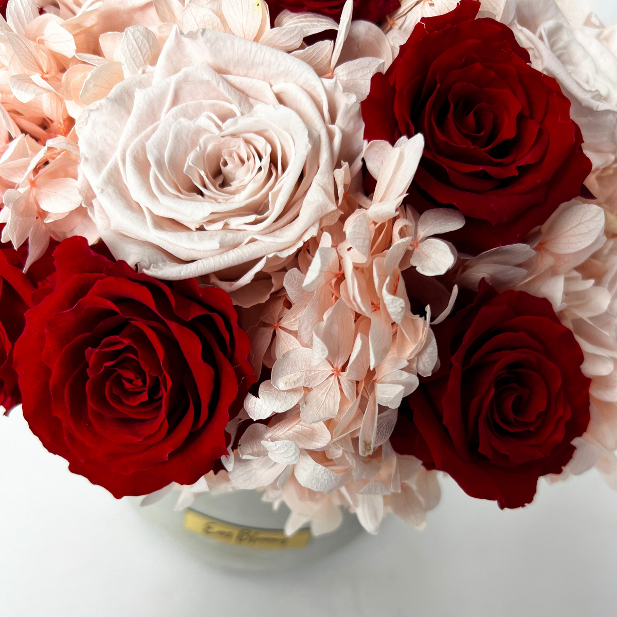The Pixie by Eos Blooms: preserved roses and pink blooms in a round glass vase.