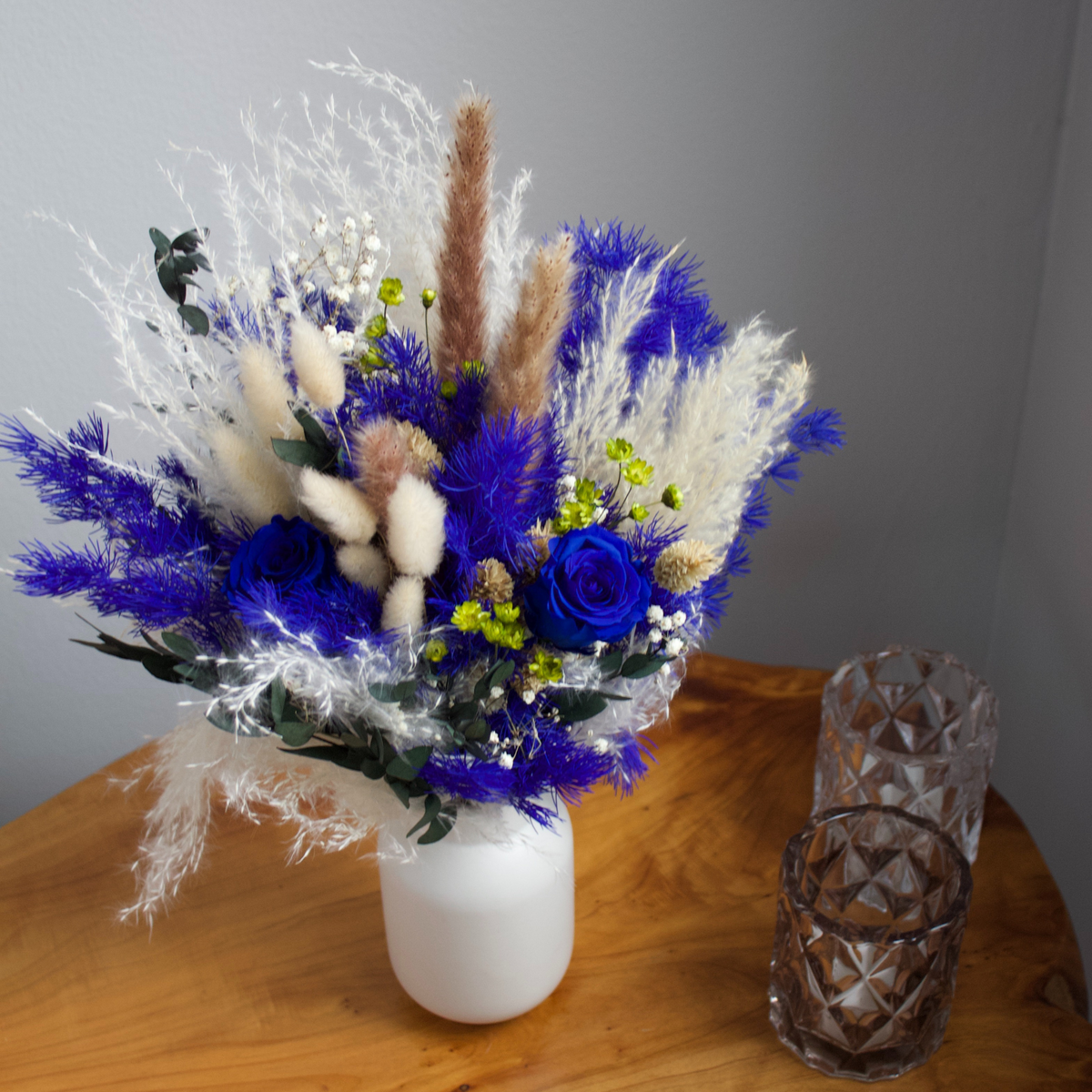 The Lazuli by Eos Blooms: royal blue blooms and dried flowers in a white vase arrangement.