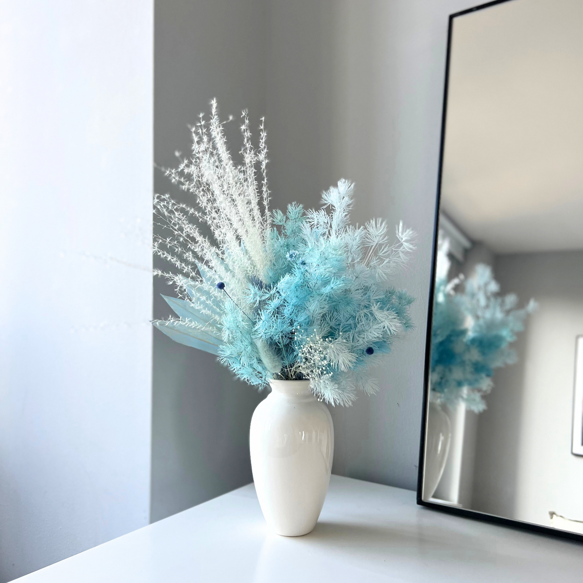 Serenity by Eos Blooms: an elegant white vase with blue and white dried flowers.