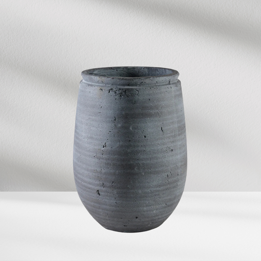 The Eos Blooms Carthage Vase in stone gray sits on a white surface with subtle shadows.