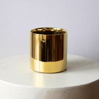 Eos Blooms Gold Cylinder on a round, white speckled surface with light gray background.