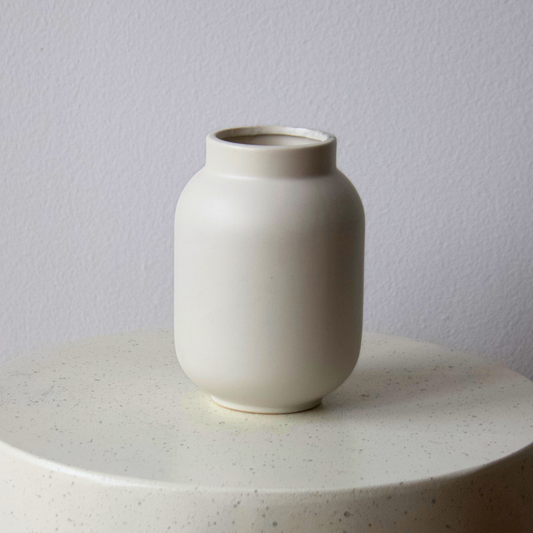 The Large SoHo Vase by Eos Blooms sits on a speckled surface by a light gray wall.