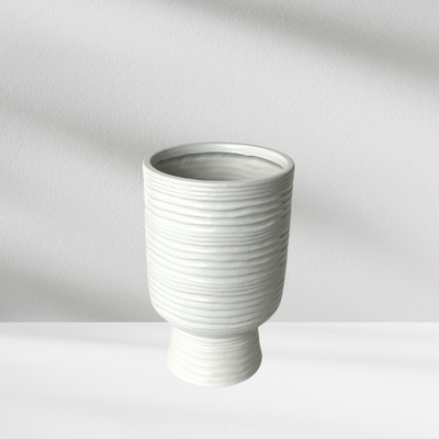 Paz Vase by Eos Blooms, ribbed ceramic with horizontal lines on a white surface.