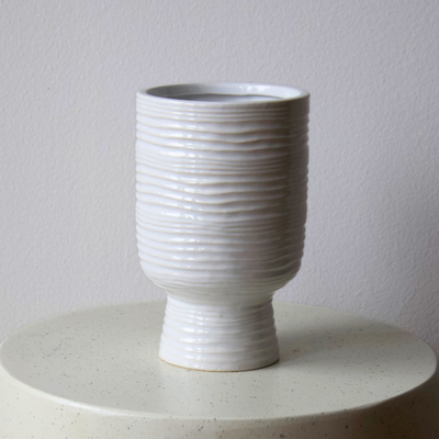 Paz Vase by Eos Blooms: a textured white ceramic piece on a light round base.