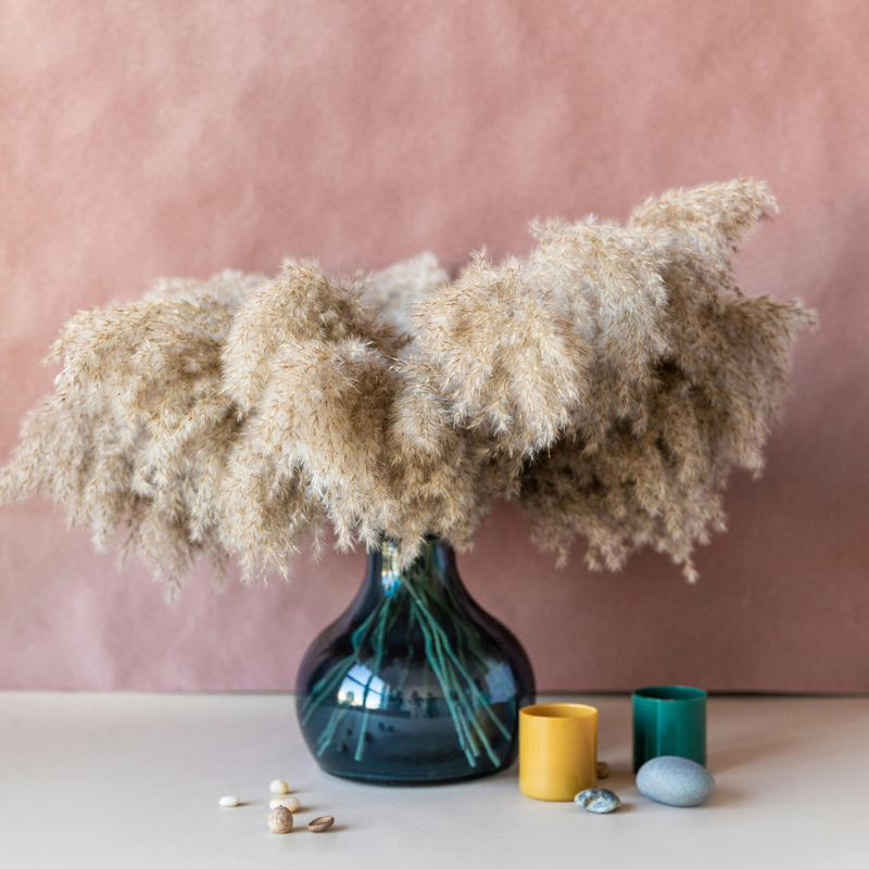 Preserved XL Pampas by Eos Blooms in a blue vase—stylish home decor with candles and stones.
