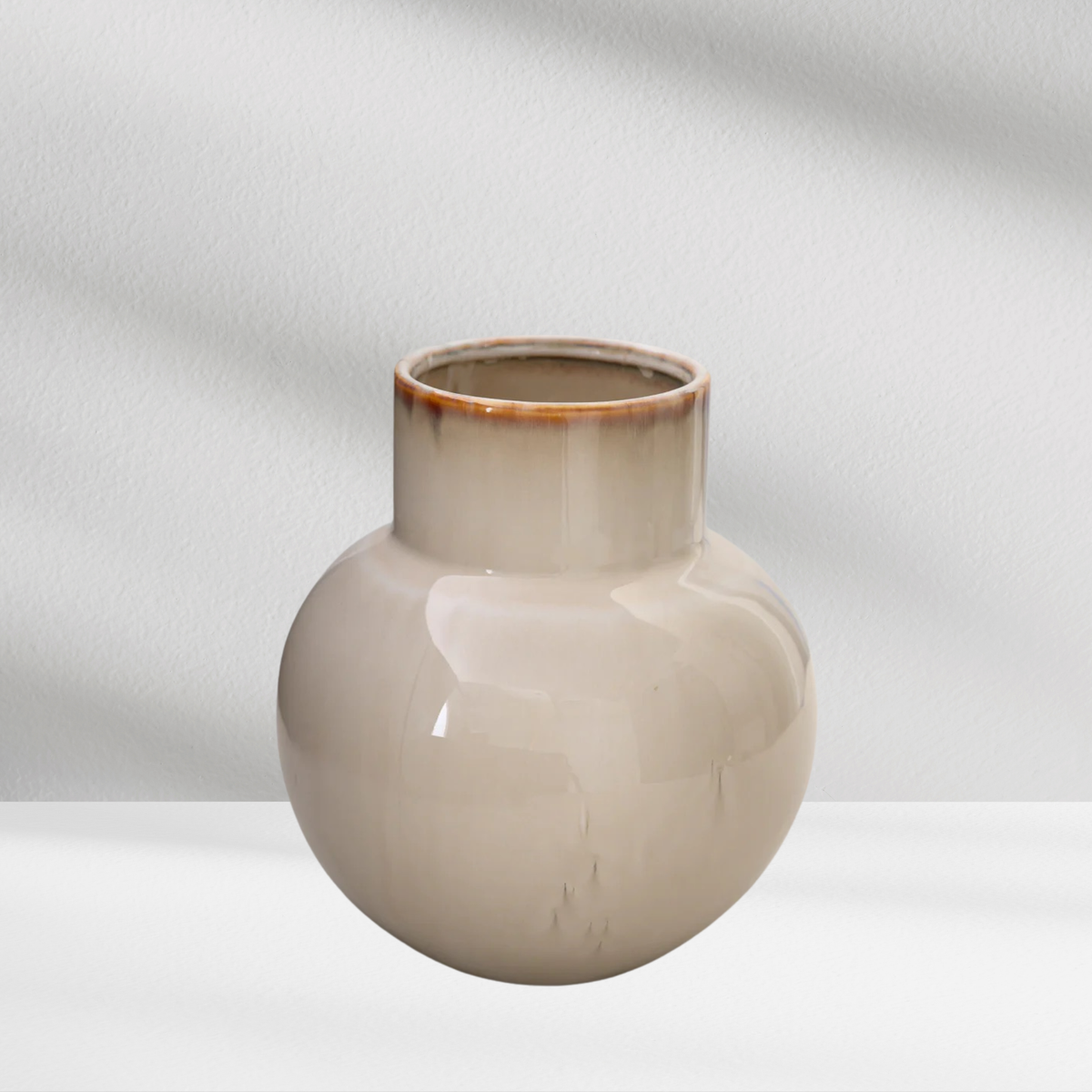 The Eos Blooms Rio Vase features glossy cream ceramic with a narrow neck and brown rim.