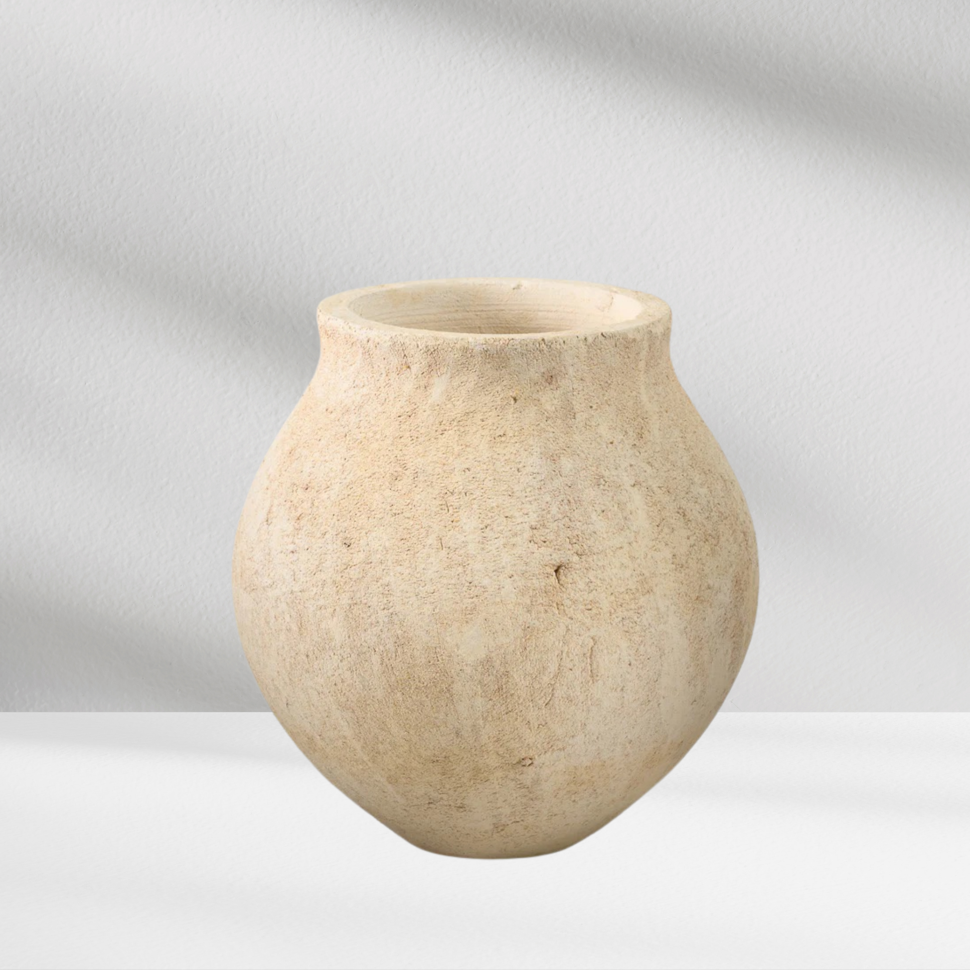 The Eos Blooms Sahara Deco Vase is a round, beige vase with a wide body and narrow opening.