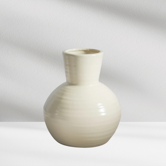 Seoul Vase by Eos Blooms: cream modern vase with round body, narrow neck, on white surface.