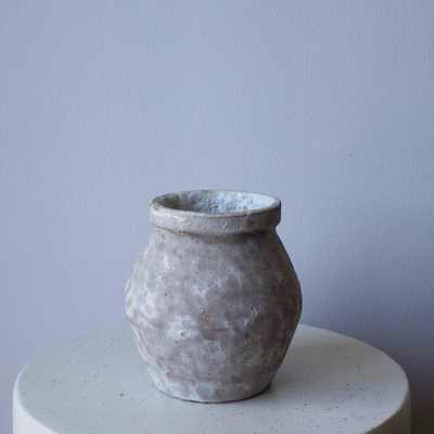 The Siena Vase by Eos Blooms brings wabi-sabi style to a white shelf and pale gray wall.