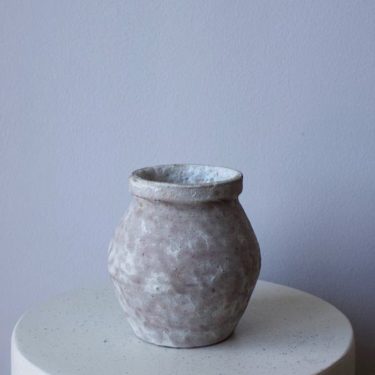 The Siena Vase by Eos Blooms brings wabi-sabi style to a white shelf and pale gray wall.