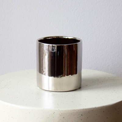 Eos Blooms Silver Cylinder vase on white textured surface with light gray wall backdrop.