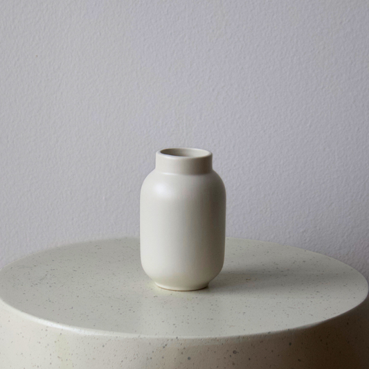 Eos Blooms Small SoHo Vase with matte finish on a round, light table against a plain wall.