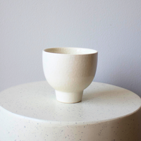 The Eos Blooms Small White Pedestal stands on a round base against a plain background.