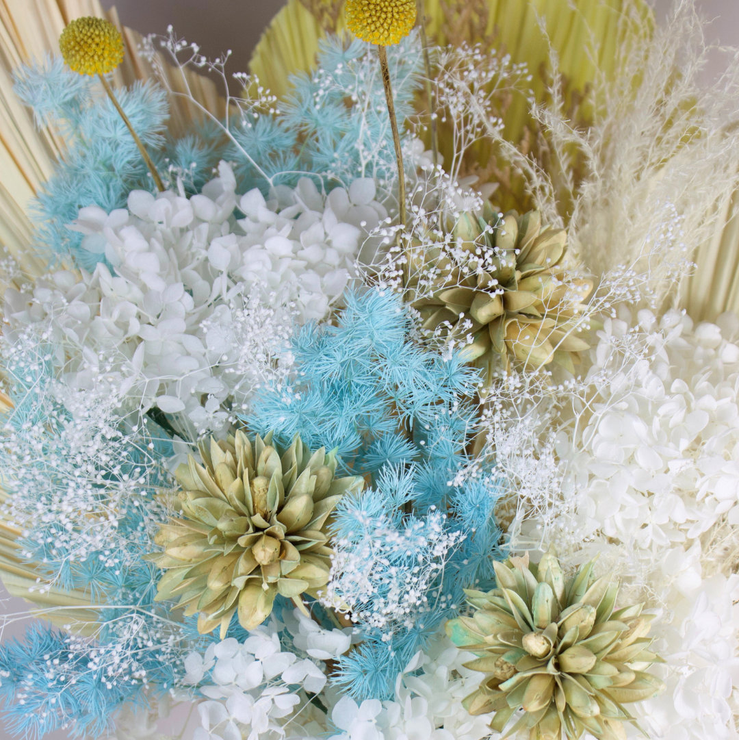 The Calypso by Eos Blooms: a coastal preserved flower arrangement in white, blue, and beige.