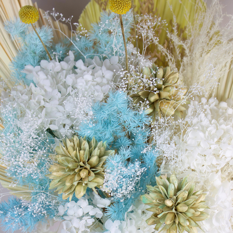 The Calypso by Eos Blooms: a coastal preserved flower arrangement in white, blue, and beige.