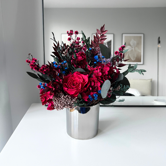 The Cerise (Petite) by Eos Blooms: preserved luxury flowers in a silver vase on a white table.