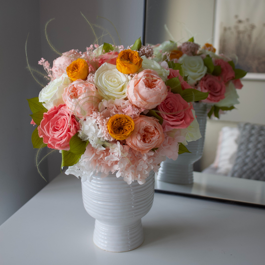 The Glimmer by Eos Blooms: pink, white & orange preserved roses in a white vase.