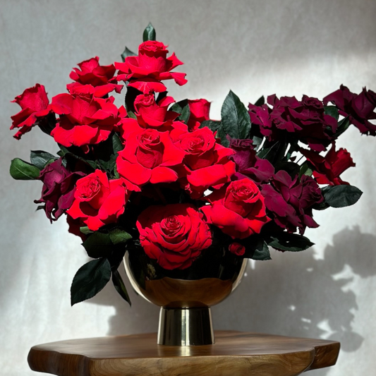 The Juliet by Eos Blooms displays hand-reflexed roses in a gold vase on a sunny table.